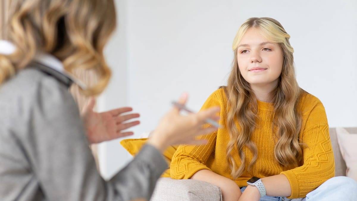 Child psychologist consultation with a young person in a comfortable setting.